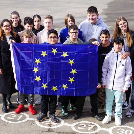 Schulklasse auf Pausenhof mit Europaflagge