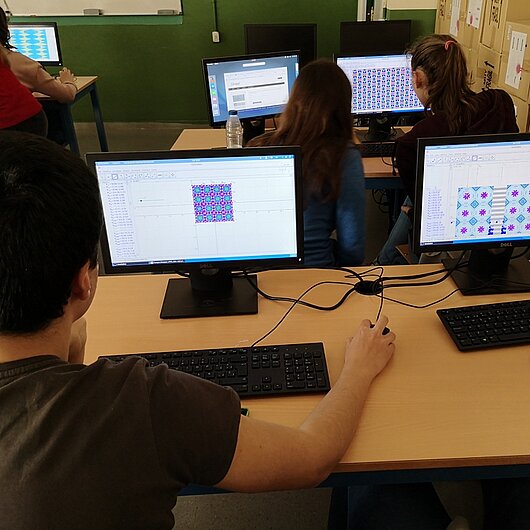 Schülerinnen und Schüler arbeiten im Klassenraum am PC