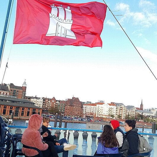 Scjhülerinnen und Schüler auf einem Schiff bei einer Hafenrundfahrt durch Hamburg