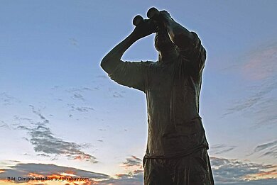 Skulptur eines Mannes, der durch ein Fernglas schaut